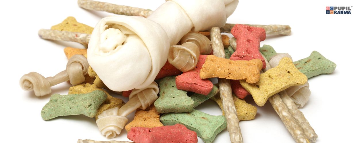 Smaczki to dodatkowa ilość kalorii. Na białym tle różne gatunki smaczków dla psa. Logo pupilkarma.